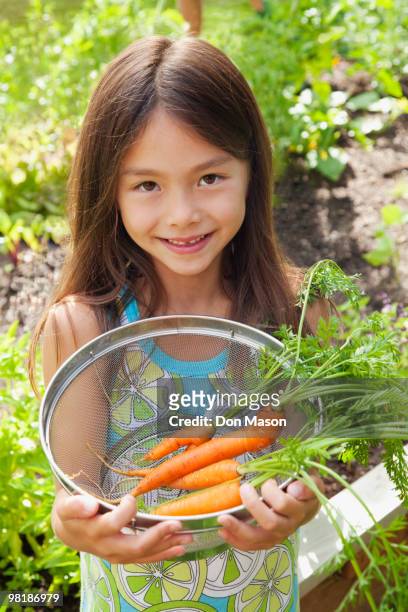 mixed race girl holding carrots - contea di whatcom foto e immagini stock