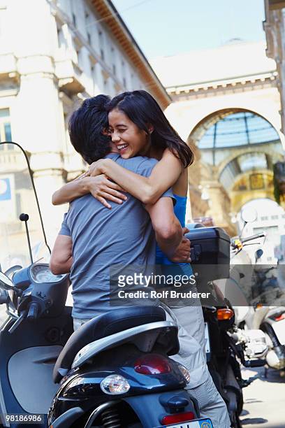 man on scooter hugging girlfriend - introducing girlfriend stock pictures, royalty-free photos & images