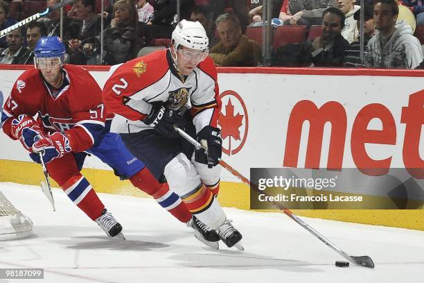 Keith Ballard of Florida Panthers skates with the puck in front of Benoit Pouliot of the Montreal Canadiens during the NHL game on March 25, 2010 at...