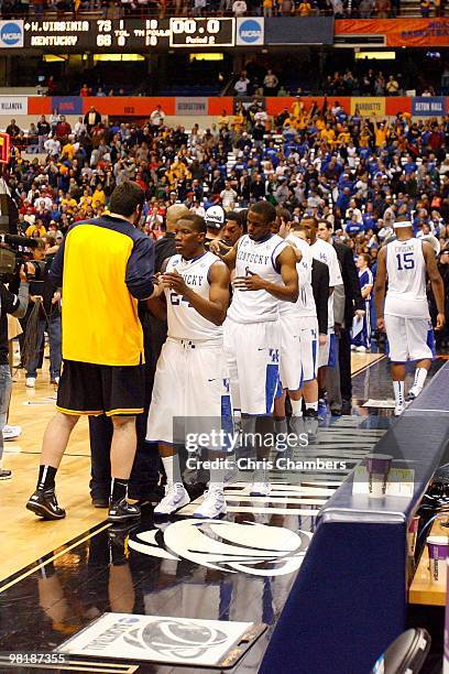 Eric Bledsoe and Darius Miller of the Kentucky Wildcats and his teammates congratulate the West Virginia Mountaineers on West Virginia's 73-66 win...