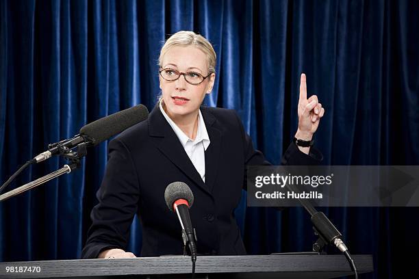 a woman in a suit speaking at a lectern - politicians female stock pictures, royalty-free photos & images