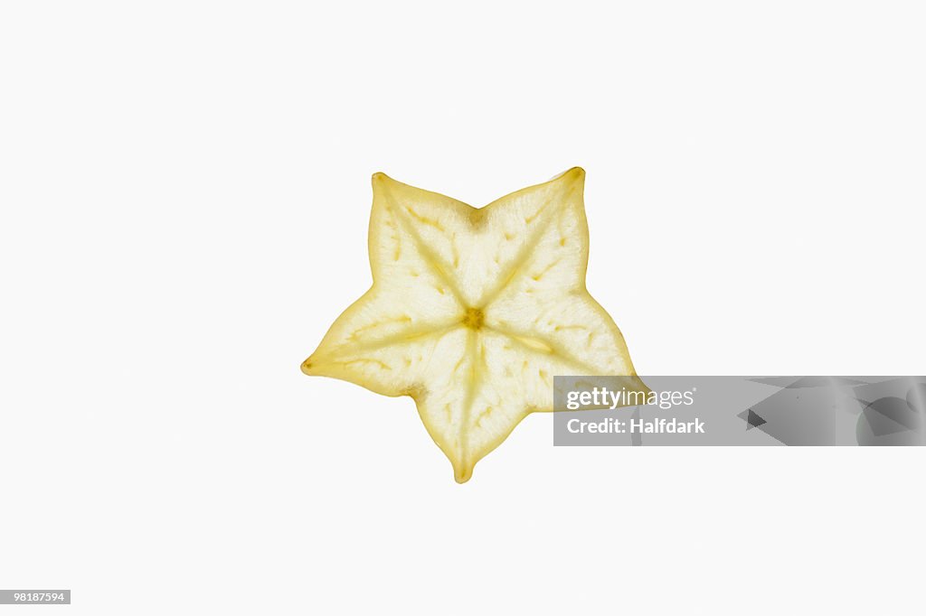 A slice of an organic carambola on a lightbox