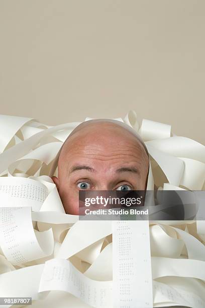 detail of a man buried in printed receipts - draft portraits photos et images de collection