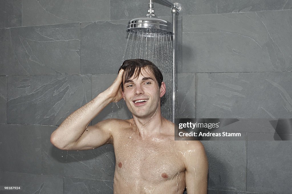 A man standing underneath a shower