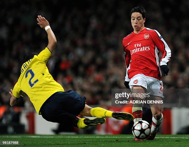 Barcelona's Brazilian defender Dani Alves jumps into a challenge against Arsenal's French midfielder Samir Nasri during the UEFA Champions League...