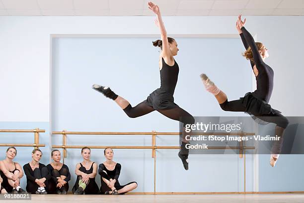 two ballerinas leaping through the air as others look on - ballet dancers russia stock-fotos und bilder