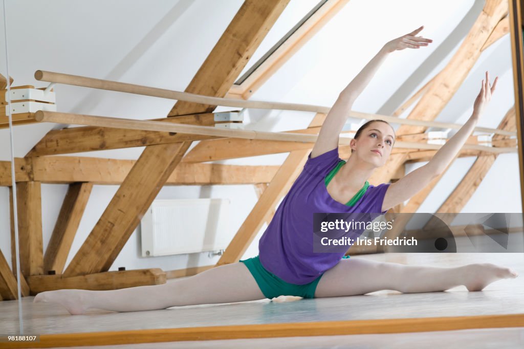 A Ballet Dancer Doing The Splits In Front Of A Mirror In A Ballet ...