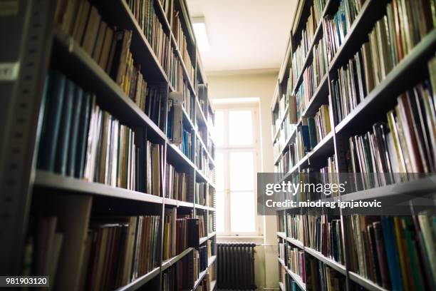 library aisle with bookshelves - history textbook stock pictures, royalty-free photos & images