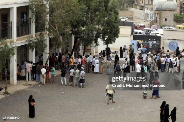 Yemeni displaced families wait to register their names in order to obtain a shelter after they fled their homes during fighting and airstrikes...