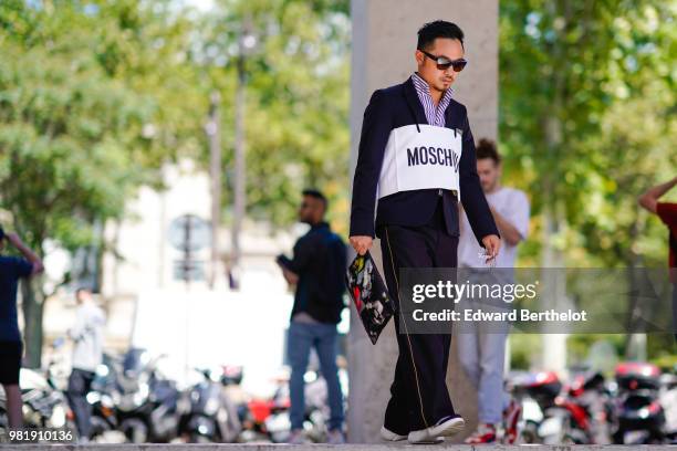 Guest wears a striped shirt, a blazer jacket, a Moschino white feature, outside Juun J, during Paris Fashion Week - Menswear Spring-Summer 2019, on...