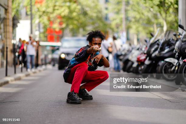 Guest wears a colored top, red pants, outside CDG Comme des Garcons, during Paris Fashion Week - Menswear Spring-Summer 2019, on June 22, 2018 in...