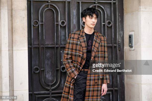 Guest wears a checked brown coat, outside Cerruti, during Paris Fashion Week - Menswear Spring-Summer 2019 on June 22, 2018 in Paris, France.