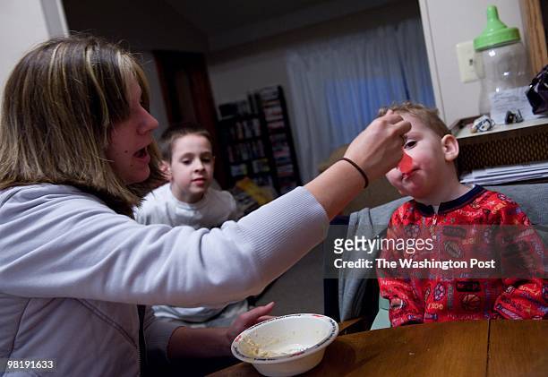 Jennifer Cline feeds her two-year-old son, Jayden Cline oatmeal early in the morning in their Monroe, Michigan home on March 23, 2010. In the center...