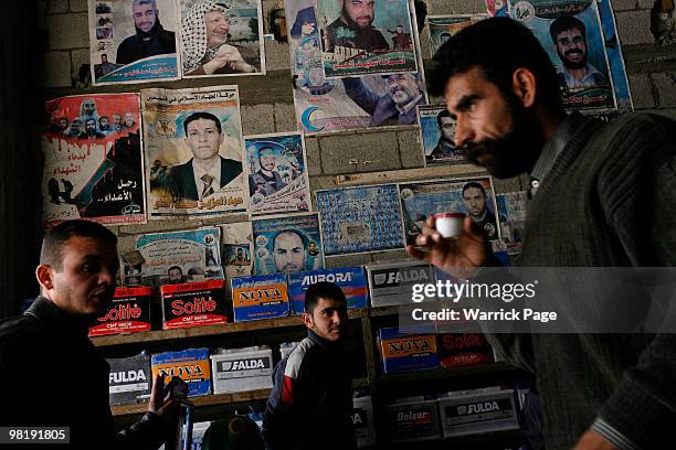 Palestinian worker, Shaher al-Helou speaks to customers at his car-battery workshop March 29, 2010 in Jabaliya, Gaza Strip. Workers at the...