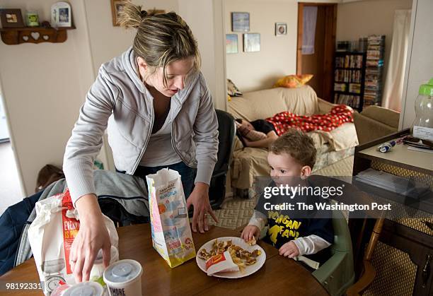 Jennifer Cline of Monroe, Michigan feeds her two-year-old son, Jayden Cline, a happy meal for lunch on March 23, 2010. In the living room Jason Cline...