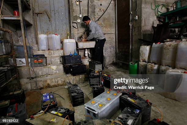 Palestinian worker, Shadi al-Helou washes his hands after making repairs at a car-battery shop March 29, 2010 in Jabaliya, Gaza Strip. Workers at the...