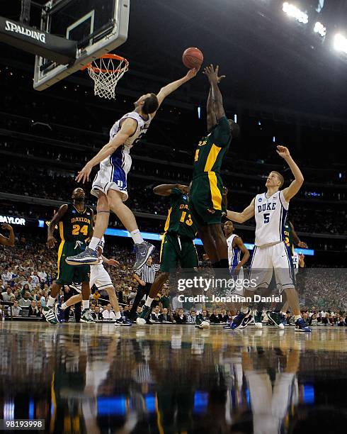 Miles Plumlee of the Duke Dlue Devils leaps for a rebound in front of Quincy Acy of the Baylor Bears during the south regional final of the 2010 NCAA...