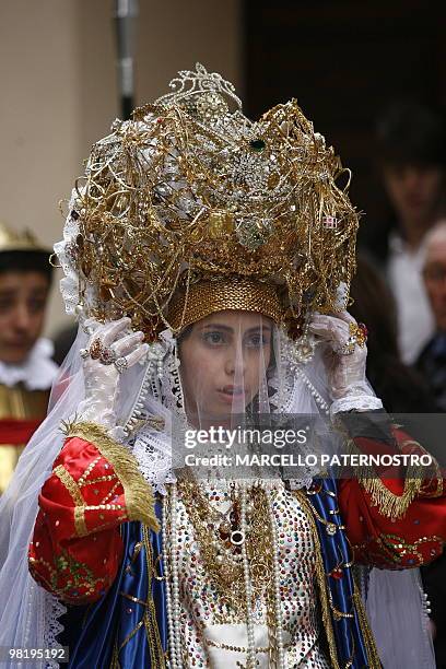 Penitent adjusts her hat during an annual procession taking place on Holy Thursday in Marsala, on the italian island of Sicily on April 1, 2010....