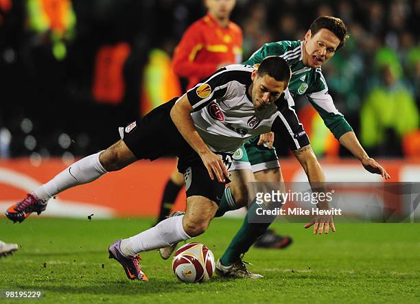Clint Dempsey of Fulham is tripped by Sascha Riether of VfL Wolfsburgduring the UEFA Europa League quarter final first leg match between Fulham and...