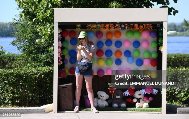 Woman waits for customers at a stand setup along the Volga river in Samara, one of the host cities of the Russia 2018 World Cup football tournament,...