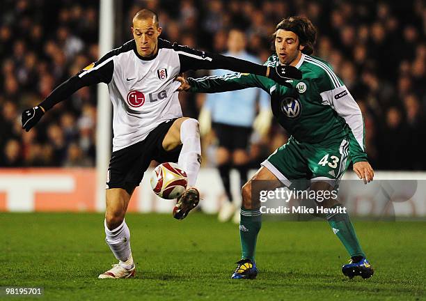 Bobby Zamora of Fulham holds off Andrea Barzagli of VfL Wolfsburg during the UEFA Europa League quarter final first leg match between Fulham and Vfl...