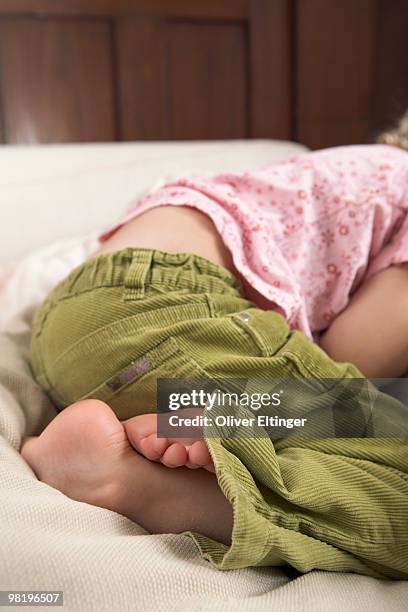 girl curled up on bed - oliver eltinger stock pictures, royalty-free photos & images