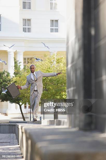 businessman balancing on a wall - portraits fun mobile wall stock-fotos und bilder