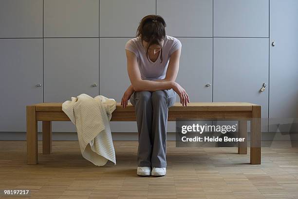 a woman resting in a locker room - locker stock pictures, royalty-free photos & images
