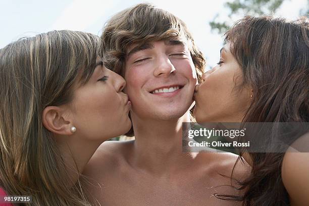 girls kissing the cheeks of boy - chest kissing stockfoto's en -beelden