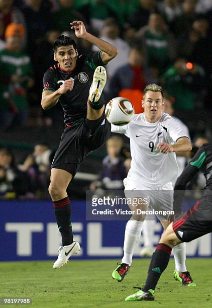 Carlos Salcido of Mexico wins a high ball as Shane Smeltz of New Zealand looks on during their International Friendly match at the Rose Bowl on March...