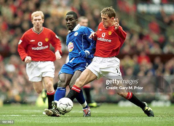Ade Akinbiyi of Leicester City challenges with Phil Neville of Manchester United during the FA Carling Premiership match between Manchester United v...