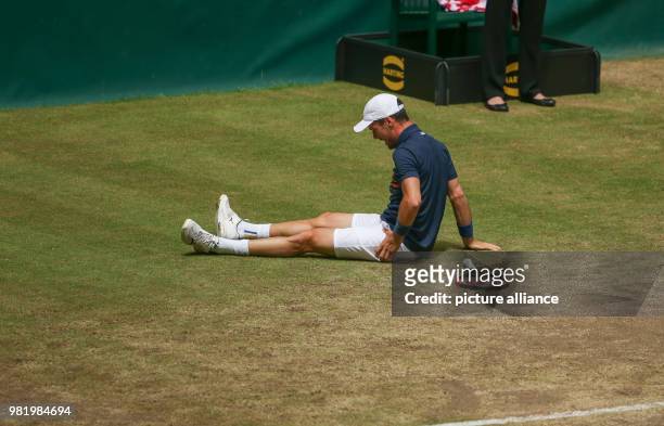 June 2018, Germany, Halle: Tennis, ATP-Tour, Singles, Men, Semi-Finals: Roberto Bautista Agut from Spain lies on the ground with an injury during his...