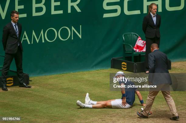 June 2018, Germany, Halle: Tennis, ATP-Tour, Singles, Men, Semi-Finals: Roberto Bautista Agut from Spain sits on the ground with an injury during his...