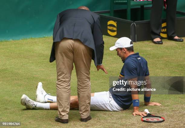 June 2018, Germany, Halle: Tennis, ATP-Tour, Singles, Men, Semi-Finals: Roberto Bautista Agut from Spain sits on the ground with an injury during his...