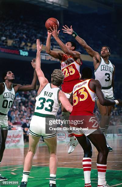 Doc Rivers of the Atlanta Hawks goes up for a shot against Larry Bird of the Boston Celtics during a game played in 1985 at the Boston Garden in...