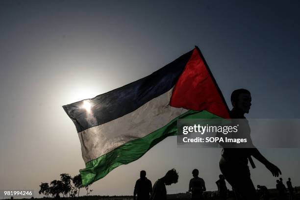 Palestinian youth raise the flag of Palestine east of Gaza City. Clashes between Palestinian civilians and Israeli soldiers broke out once again at...