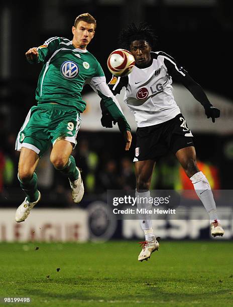Dickson Etuhu of Fulham jumps with Edin Dzeko of VfL Wolfsburg during the UEFA Europa League quarter final first leg match between Fulham and Vfl...
