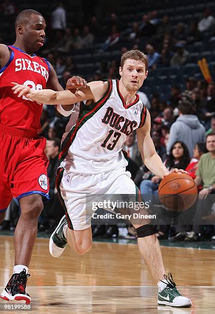 Luke Ridnour of the Milwaukee Bucks drives against Jodie Meeks of the Philadelphia 76ers during the game on March 24, 2010 at the Bradley Center in...