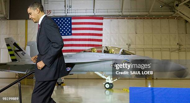 President Barack Obama exits the stage with a FA-18 "Green Hornet," fueled by advanced biodiesel, behind after speaking on energy security at Andrews...
