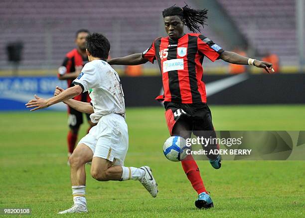 Bio Paulin of Indonesia's Persipura Jayapura vies the ball as Nozawa Japan's Kashima Antlers tries to block him during their AFC champion's league...