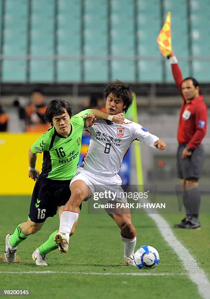 Shin Kwang-Hoon of South Korea's Jeonbuk Motors fights for the ball with Du Zhenyu of China's Changchun Yatai FC during a preliminary Group F match...