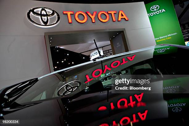 Toyota logo is reflected in the back windshield of a Prius plug-in hybrid on display during a media preview of the New York International Auto Show...