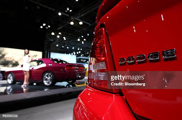 Model stands next to the 2010 Dodge Challenger R/T classic during a media preview of the New York International Auto Show in New York, U.S., on...