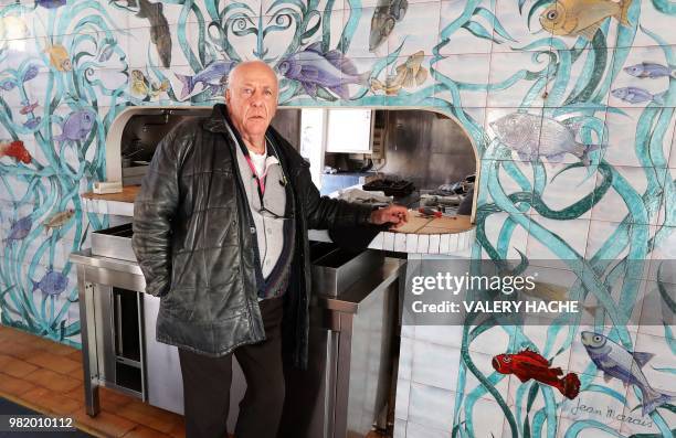 In this file photo taken on January 31, 2018 Gilles Esmiol poses in front of a fresco, painted by French sculptor Jean Marais and listed as a...