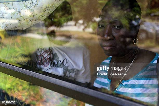 Gizelle Georges and her boyfriend Eddy Auguste look out the window of the home she owns currently under foreclosure April 1, 2010 in Miami, Florida....