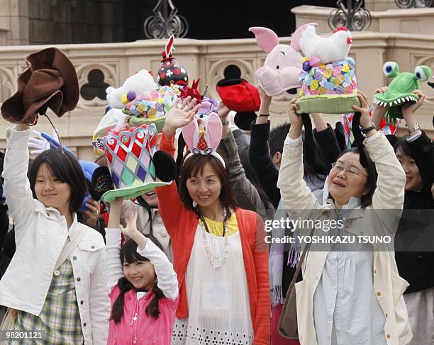 Guests wave their mad hats during the press preview for the new parade "Easter Bonnet Party" at the Tokyo Disneyland at Urayasu city, suburban Tokyo...