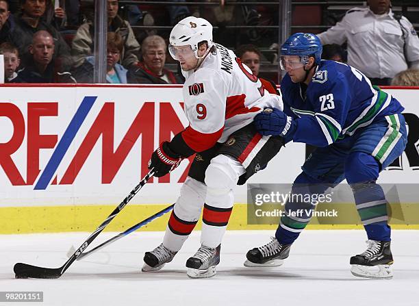Alexander Edler of the Vancouver Canucks checks Milan Michalek of the Ottawa Senators during the game at General Motors Place on March 13, 2010 in...
