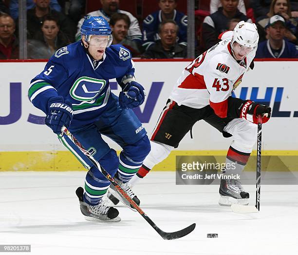 Peter Regin of the Ottawa Senators chases Christian Ehrhoff of the Vancouver Canucks as he skates up ice with the puck during the game at General...