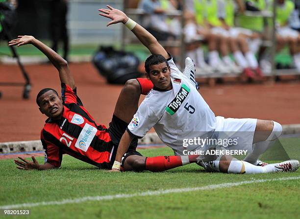 Yustinus Pae of Indonesia's Persipura Jayapura and Gilton Ribiera of Japan's Kashima Antlers fall together as they fail to reach the ball during...