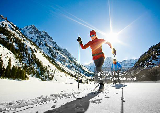 front-view of two female nordic skiers skiing. - langlaufen stock-fotos und bilder